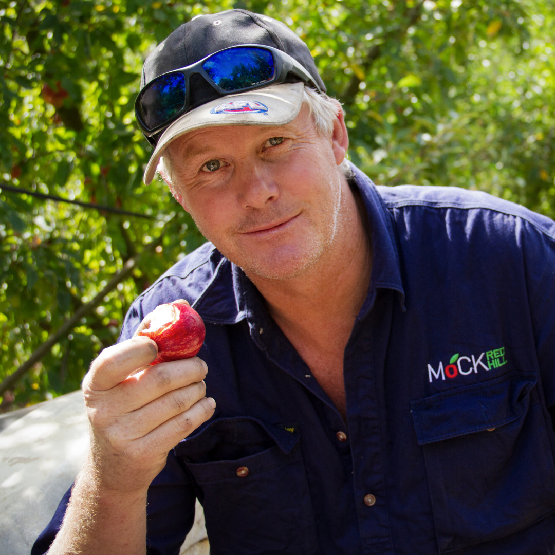 Farm owner holding an apple